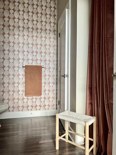 a bathroom with a white toilet sitting next to a wooden bench in front of a window