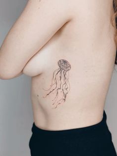 a woman's stomach with a tattoo of a jellyfish on her right side