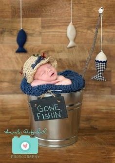 a baby is laying in a bucket with a sign hanging from it's side