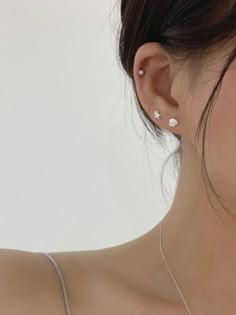 a close up of a person wearing a necklace and earring