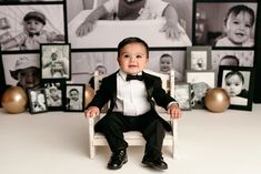 a little boy in a tuxedo sitting on a white chair with photos behind him