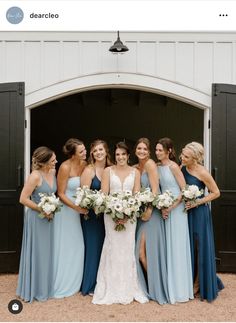 a group of women standing next to each other in front of a white barn door