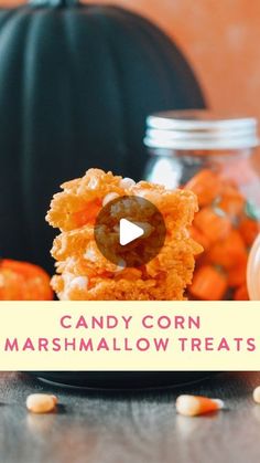 candy corn marshmallow treats on a black plate with pumpkins in the background