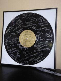 a record with autographs on it sitting on a table next to a remote control