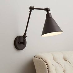 an image of a lamp on the wall next to a chair and couch in a living room