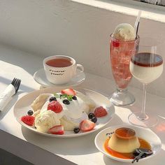 two plates with desserts and drinks on a window sill next to each other