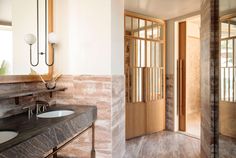 two sinks and mirrors in a bathroom with wood trimmings on the walls, along with an open door