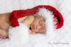 a newborn baby wearing a red and white santa hat