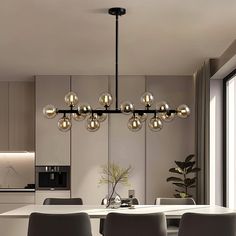 a dining room table with chairs and a chandelier hanging from it's ceiling