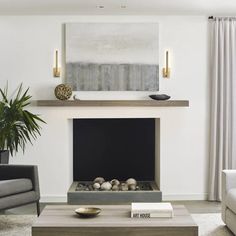 a living room with a couch, coffee table and painting on the fireplace mantel