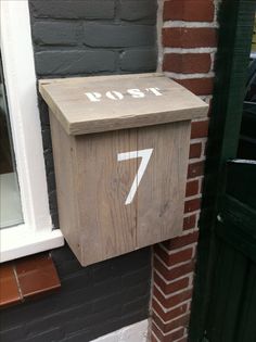 a wooden mailbox sitting on the side of a building