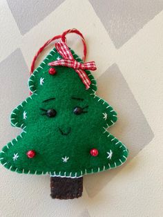 a felt christmas tree ornament hanging on a wall