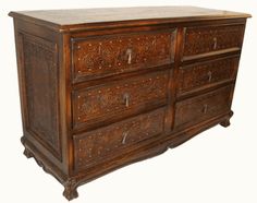 an old wooden dresser with carvings on the top and bottom drawers, against a white background