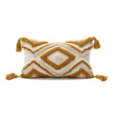 an orange and white pillow with tassels on the front, sitting on a white surface