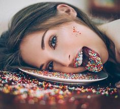 a woman laying on top of a plate covered in sprinkles