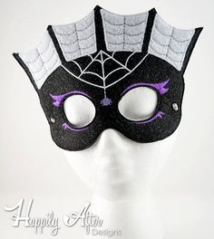 a white mannequin head wearing a black and purple mask with spider web on it