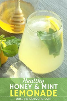 a lemonade drink in a glass with mint and honey on the side