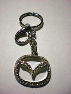 a silver keychain with a heart and an arrow on it's side