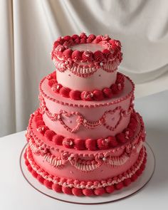 a three tiered cake with pink frosting and beading on it's sides