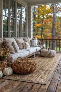 a couch sitting on top of a wooden floor next to a basket filled with pumpkins