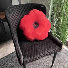 a red flower sitting on top of a black chair