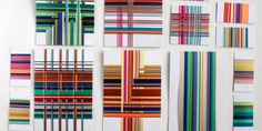 several different colored lines are arranged on the wall in this art work, which is made up of multiple strips of multicolored paper