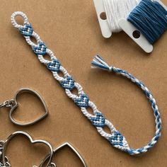 two pieces of string and scissors on a table with some other items in the background