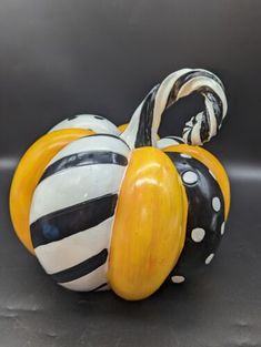 a ceramic pumpkin with black and white stripes