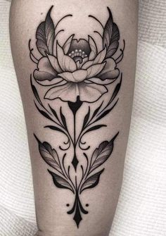 a black and white flower tattoo on the thigh