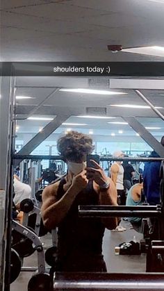 a woman taking a selfie in front of a mirror at the gym with her cell phone