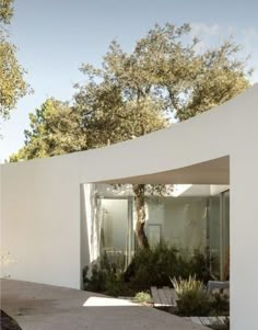 a white house with trees in the background and concrete walkway leading up to it's entrance