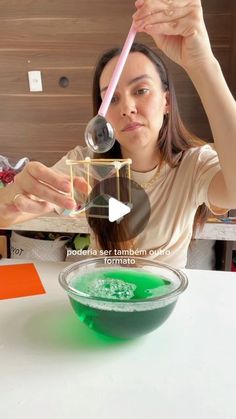 a woman is pouring green liquid into a bowl