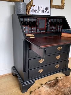 an antique desk with drawers and other items on top is shown in front of a framed photograph