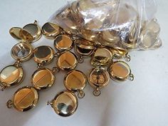 a bunch of gold colored buttons sitting on top of a white table next to a plastic bag