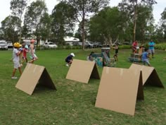 several people are playing with cardboard in the park