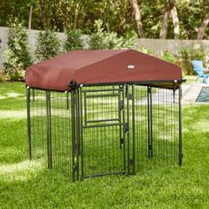 a dog cage with a cover on it in the grass next to a swimming pool