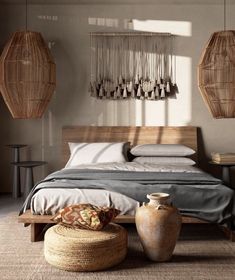 a bed sitting in a bedroom next to two vases on top of a table