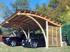 two black cars parked under a wooden carport