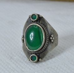 Handmade Tuareg Moroccan Silver African Berber Ethnic Ring with Green Stone - Ancient Vintage bague, Unique Gift Onyx Carnelian This exquisite vintage ring is crafted from silver, showcasing a beautifully polished green gemstone at its center. The oval-shaped stone is set within an ornate silver band, adorned with intricate detailing that reflects African Berber ethnic artistry. Smaller green stones accentuate the design, adding a harmonious and eye-catching touch. The silver band features delic Ring With Green Stone, Ring Green Stone, Silver Work, Green Gemstones, Vintage Ring, Green Stone, Turquoise Stone, Silver Band, Rings Statement