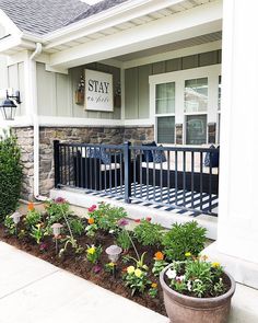 the front porch is decorated with flowers and plants