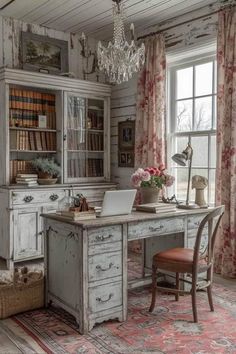 an old - fashioned desk and chair sit in front of a large window with curtains