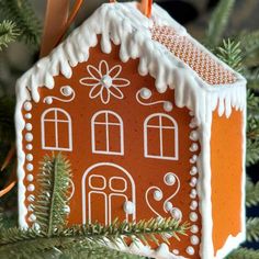 a ginger house ornament hanging from a christmas tree