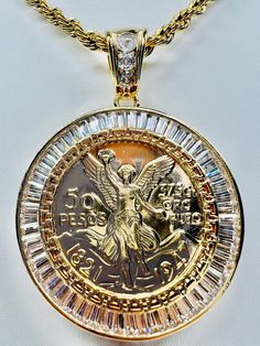 "Centenario (50 Pesos and Mexican Eagle) Double Face - 50 Pesos on front side and Mexican Eagle on the other side The pendant has the white color CZ stones Includes a 26\" Rope Gold Filled over Stainless Steel Necklace 24K Gold Filled Pendant Measures 68mm Necklace Measures 26\", 4mm Centenario de 50 Pesos y Aguila Mexicana Doble Cara - 50 Peso en Frente y Aguila Mexicana en el otro lado La medalla tiene piedras zirconia color blanco Incluye cadena torzal de 26\" de Oro Chapado sobro Acero Es de Mexican Eagle, Gold Jewels Design, Diamond Jewelry Necklace, Rope Necklace, Gorgeous Bracelet, Steel Necklace, Stainless Steel Necklace, Double Face, Cz Stone