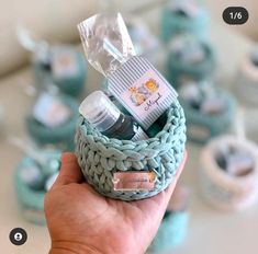 a hand holding a small basket filled with baby items