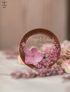 a wooden ring with pink flowers on it and the words morgan & stewart written in gold