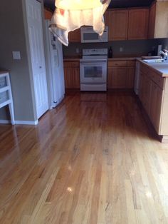 an empty kitchen with hard wood floors and white appliances