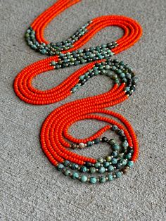 This strand features bright orange glass beads, 14k gold, and African Turquoise gemstones African Turquoise is a teal, speckled form of Jasper. Considered the “Stone of Evolution”, African Turquoise is said to bring about great change and transformation within one's life. Its encouraging energy opens minds to the possibility of newness. Traditional hand crafted waist beads. Strung on thread with no clasp. Please measure your waist in inches before placing your order to ensure correct sizing. Orange Hand-strung Multi-strand Jewelry, Orange Multi-strand Hand-strung Jewelry, Orange Natural Stones Beads, Vibrant Orange Round Bead Jewelry, Vibrant Orange Round Beaded Jewelry, Unique Orange Gemstone Beads, African Sunrise, Waist Beads, African Turquoise