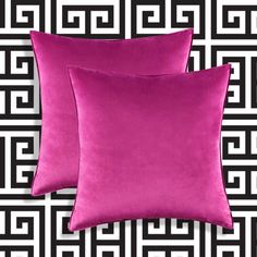 two purple pillows sitting next to each other on a black and white wallpaper background