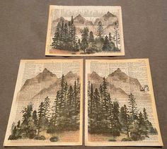 three pieces of art on top of a book with trees and mountains in the background