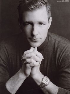 a black and white photo of a man with his hands on his chin